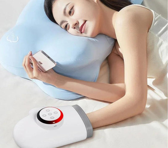 Woman relaxing with heated hand warmer and phone on bed, using ergonomic pillow for comfort