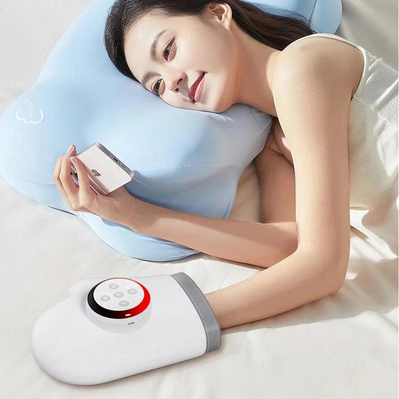Woman relaxing with heated hand warmer and phone on bed, using ergonomic pillow for comfort